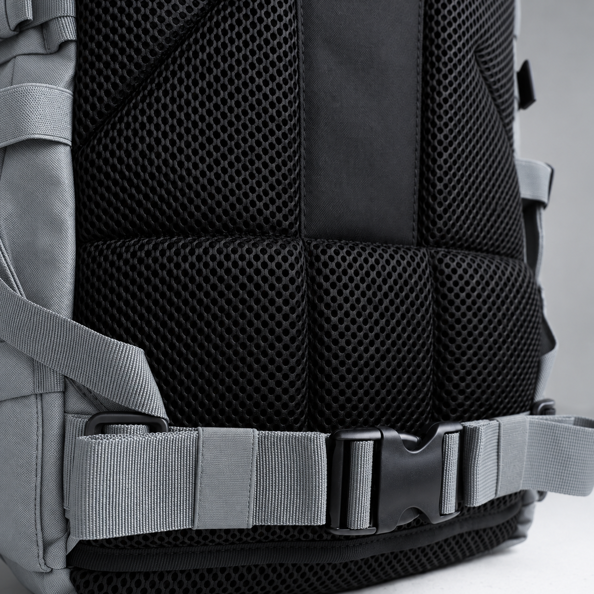 grey backpack – rear waist strap and black mesh detail