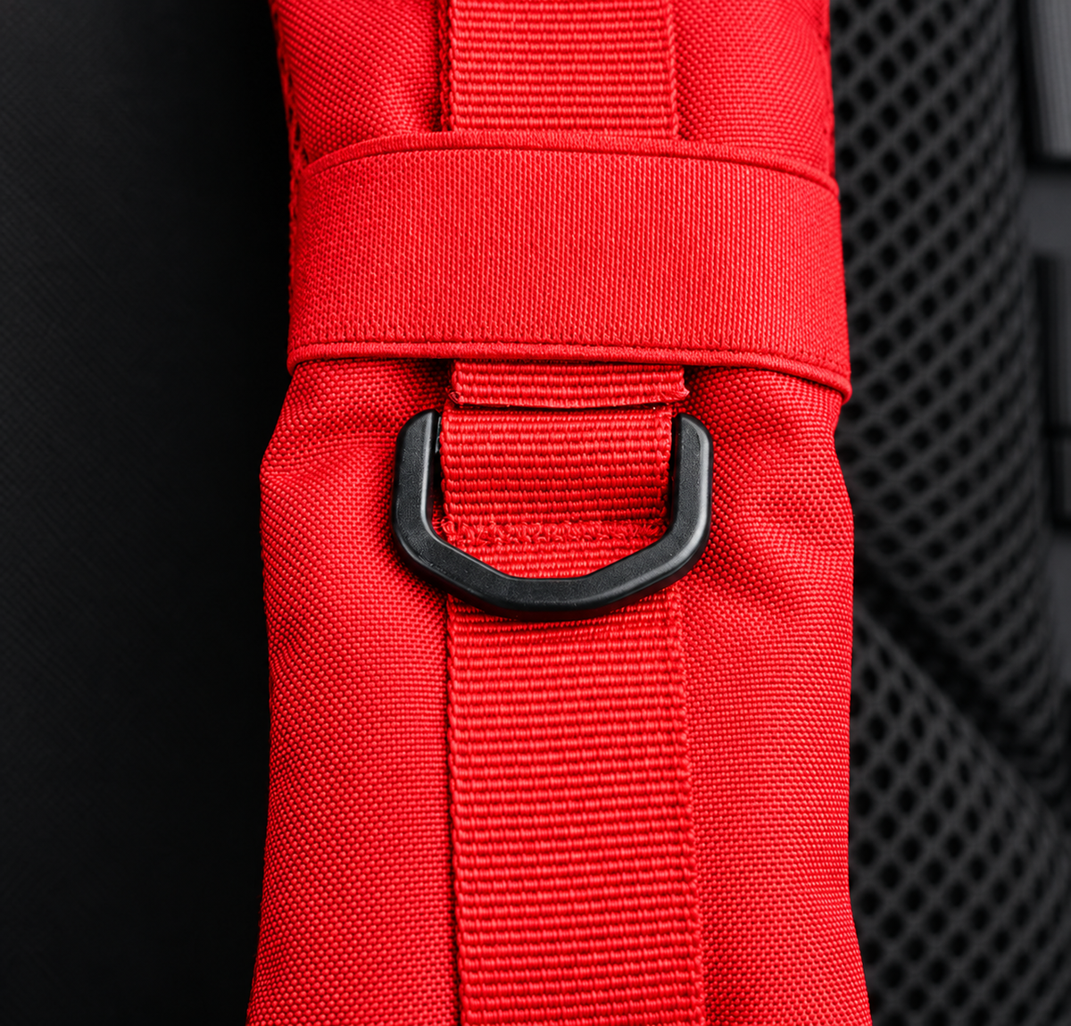 red backpack – shoulder strap with black fitting detail