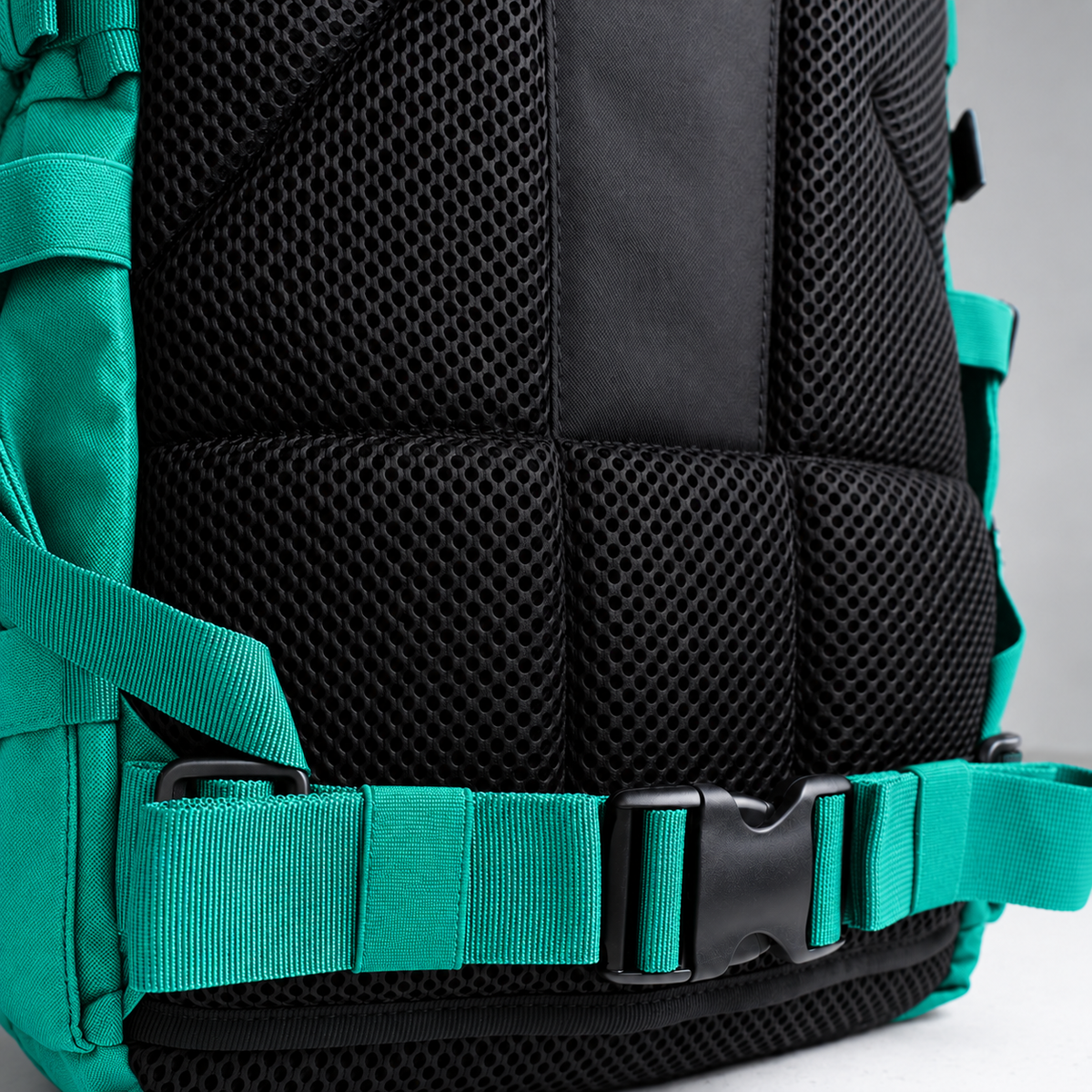teal backpack – rear waist strap and black mesh detail