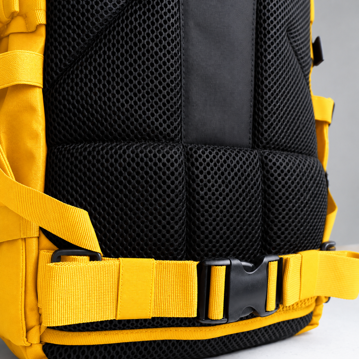 yellow backpack – rear waist strap and black mesh detail