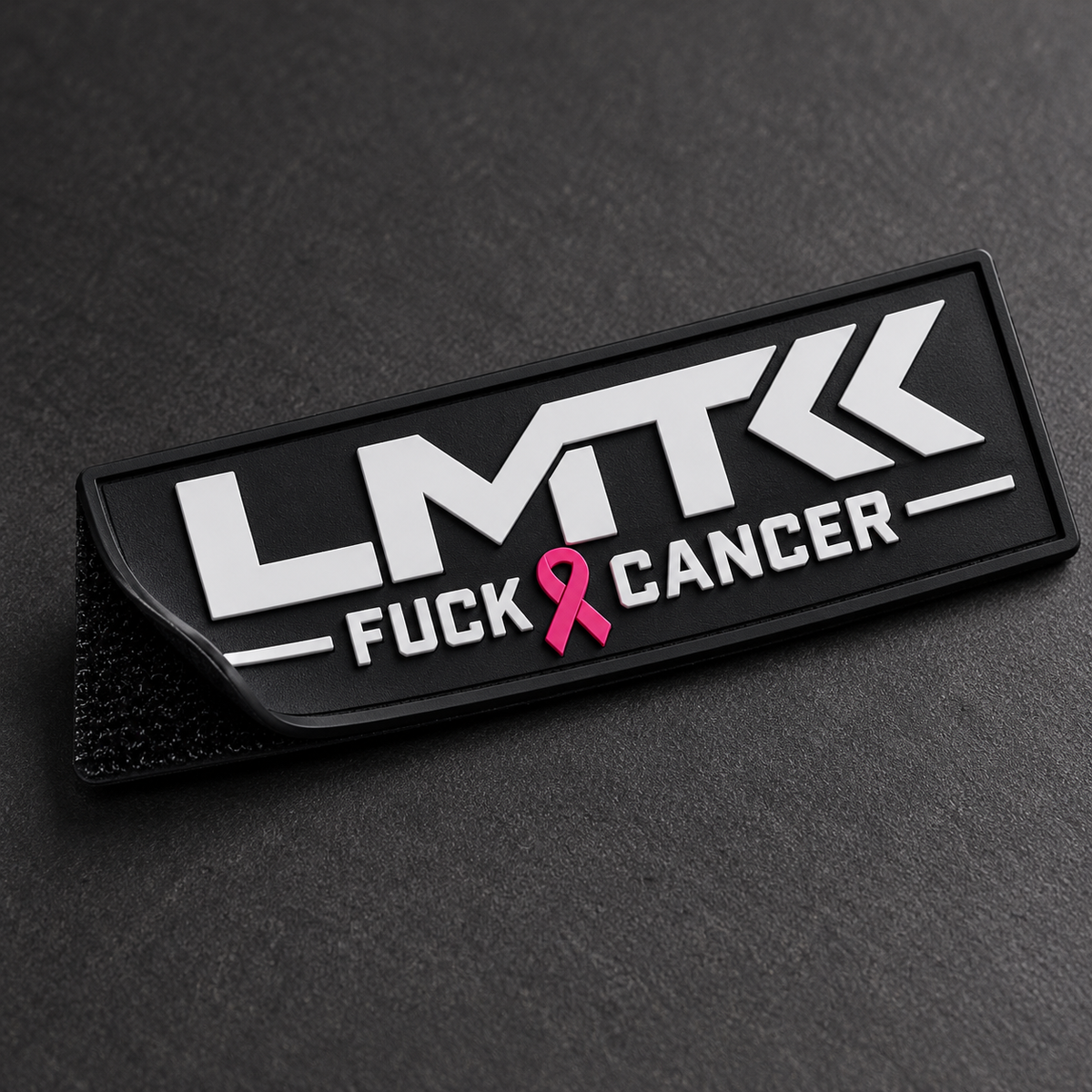 Close-up of LMT Fuck Cancer PVC bag tag showing raised design and hook-and-loop backing